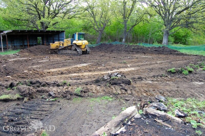 Bull dozer prepares the site pad for new barn construction